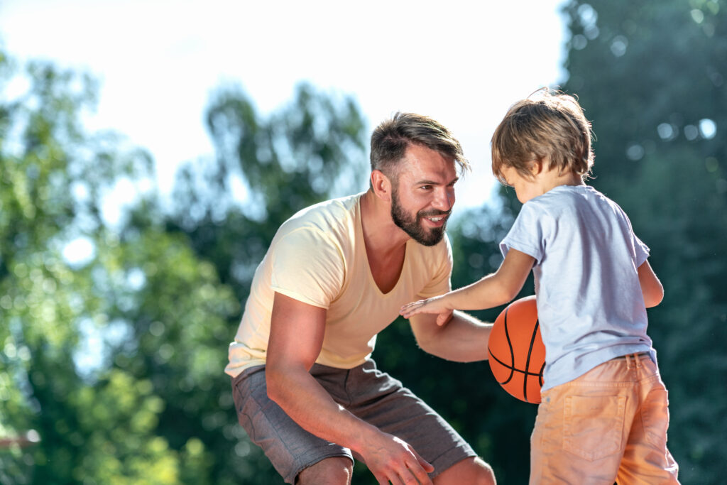 Dad and son playing basketball on the court
